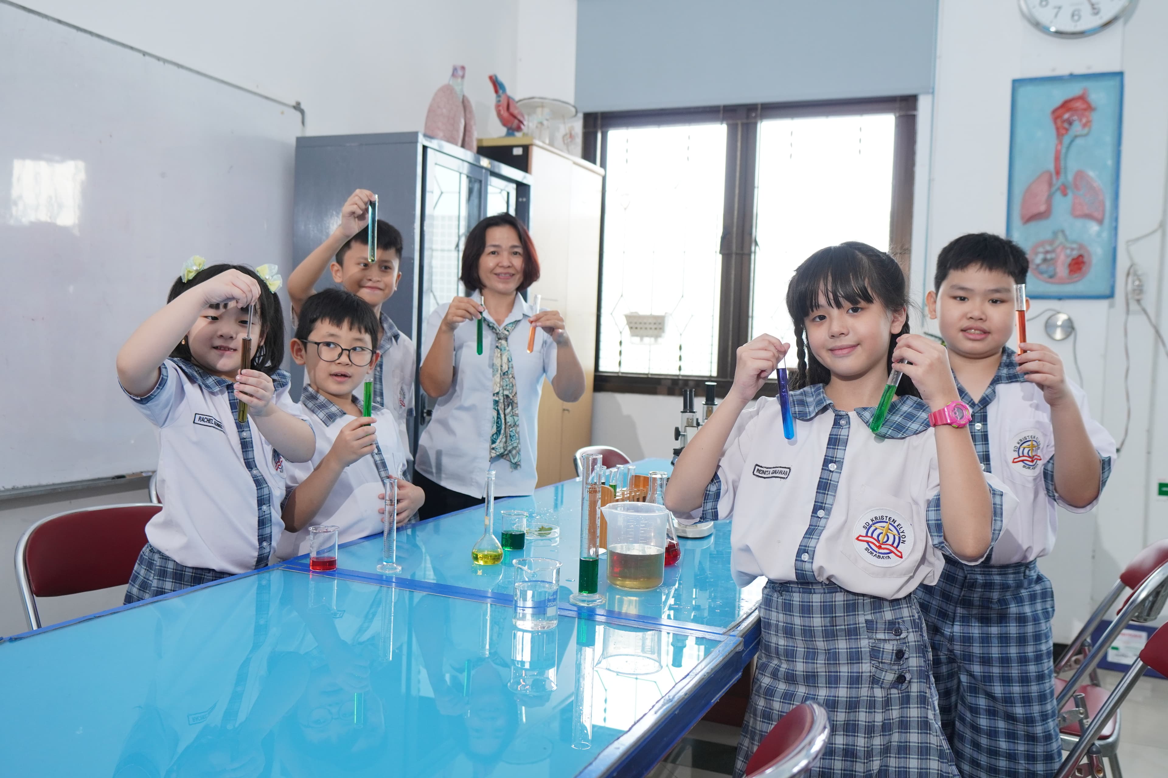 Students conducting a science experiment with their teacher